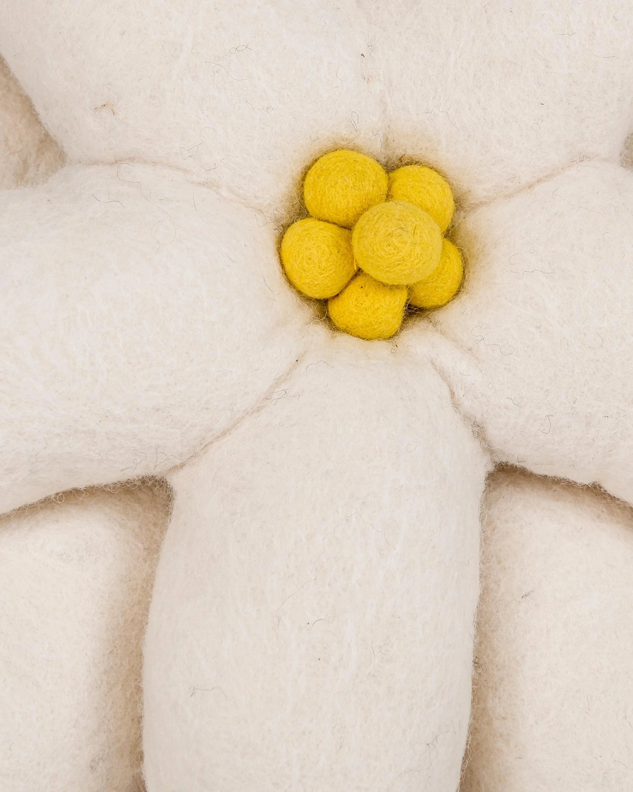 Coussin décoratif edelweiss en feutrine sur fond blanc détail zoom matière.