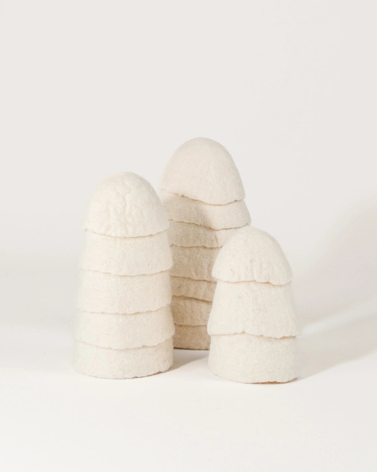 Set de 3 sapins en feutrine blanc sur un fond blanc.
