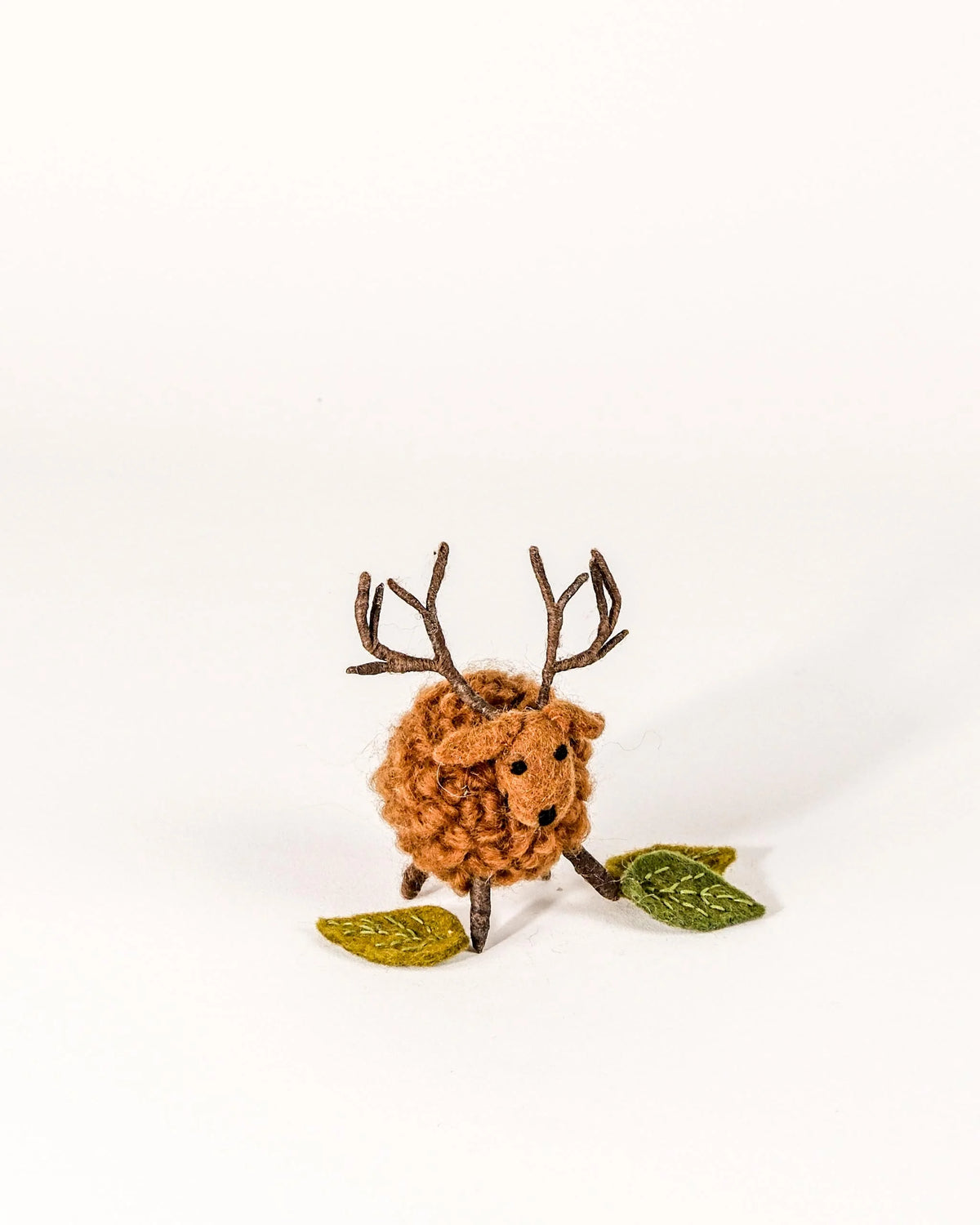 Petit cerf boule marron en feutrine sur un fond blanc.