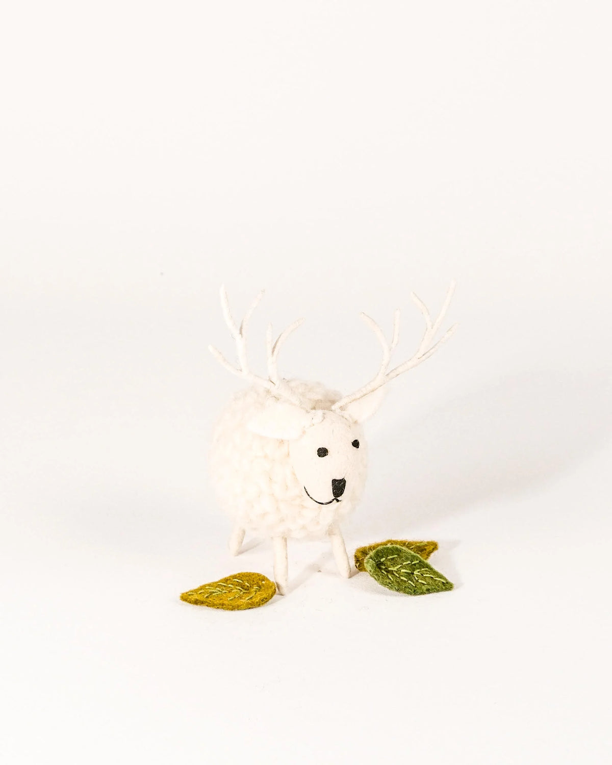 Grand cerf boule blanc en feutrine sur un fond blanc.