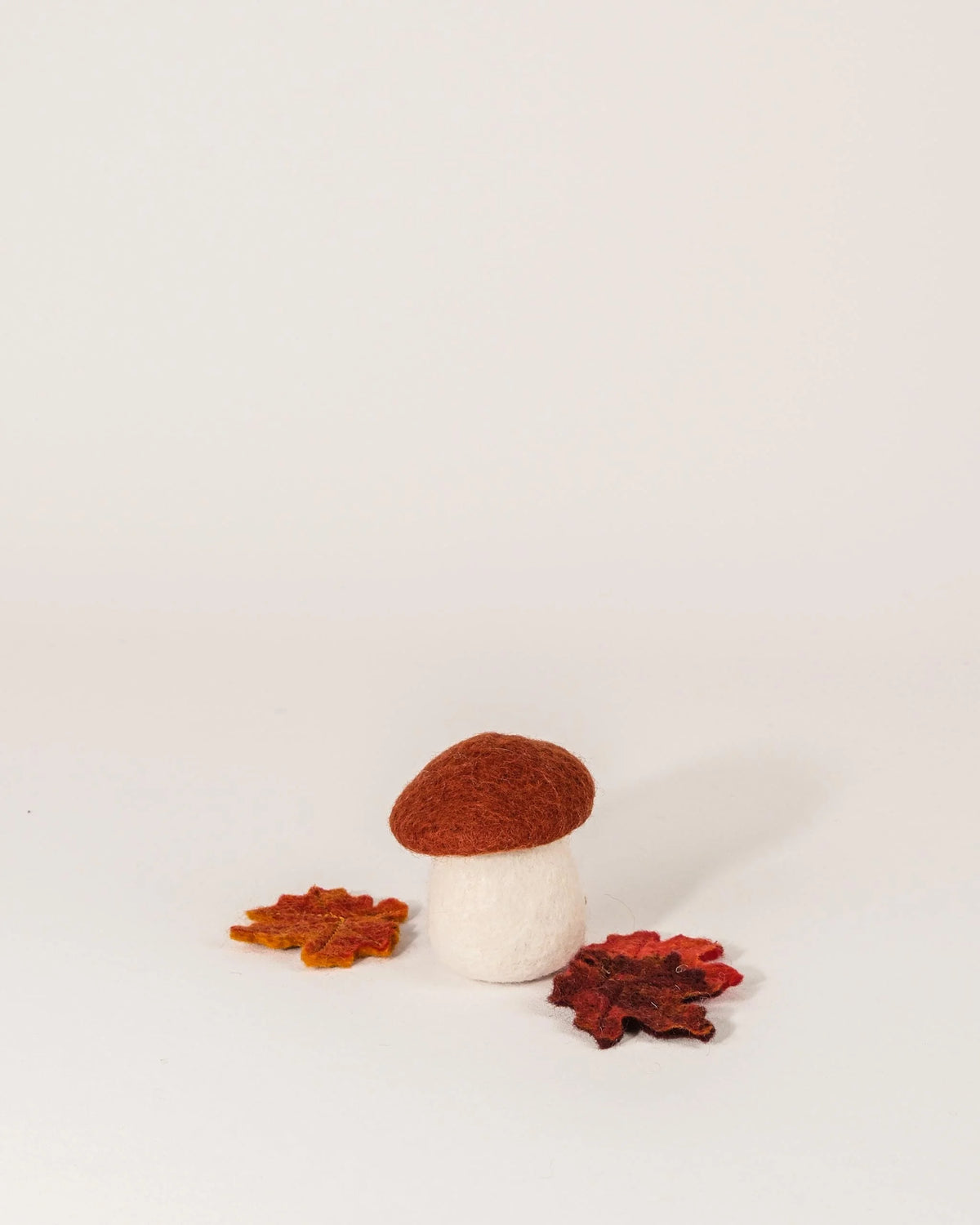 Champignon rouille en feutrine sur un fond blanc.