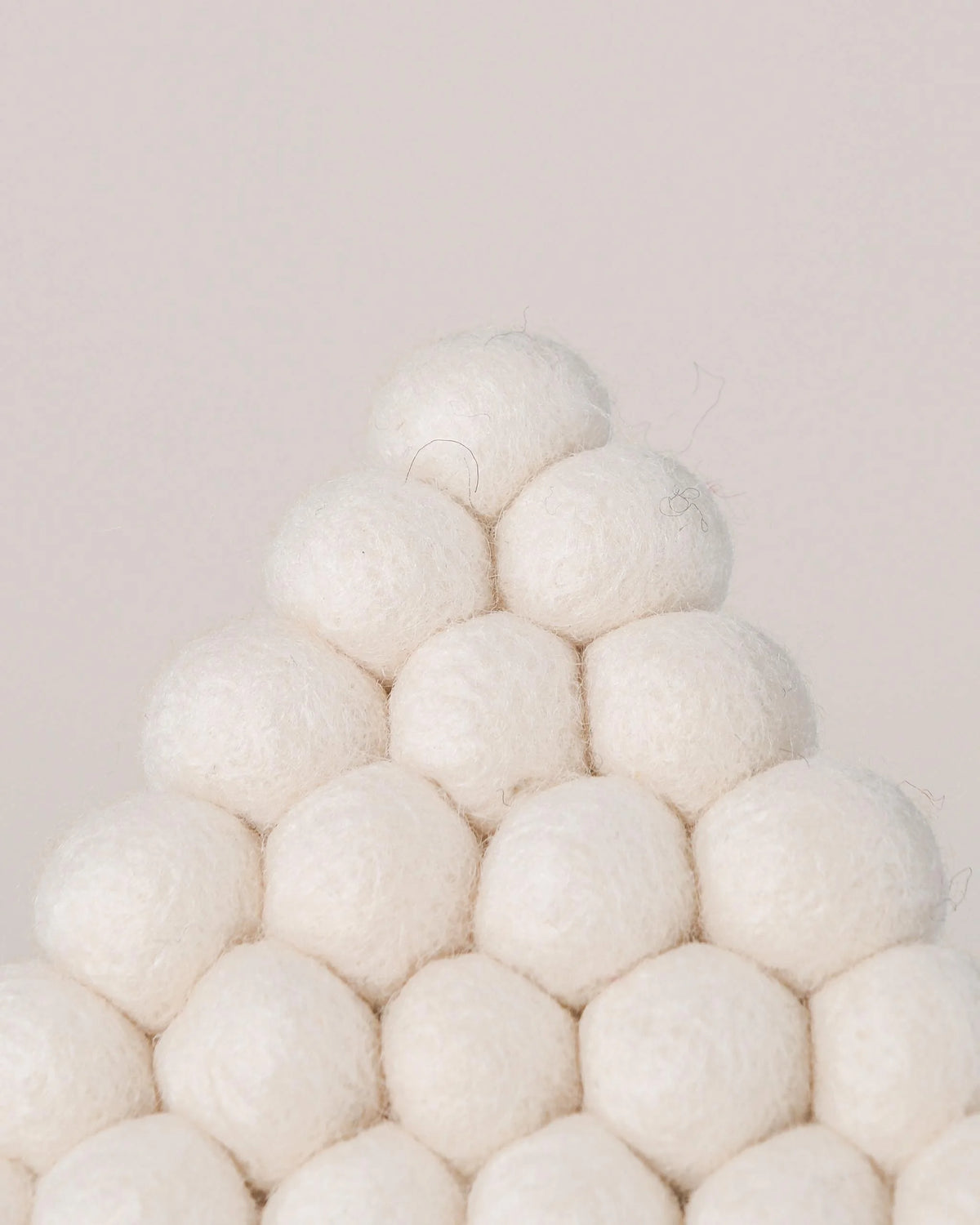 Dessous de plat boule en feutrine sapin blanc sur un fond blanc detail zoom matiere.