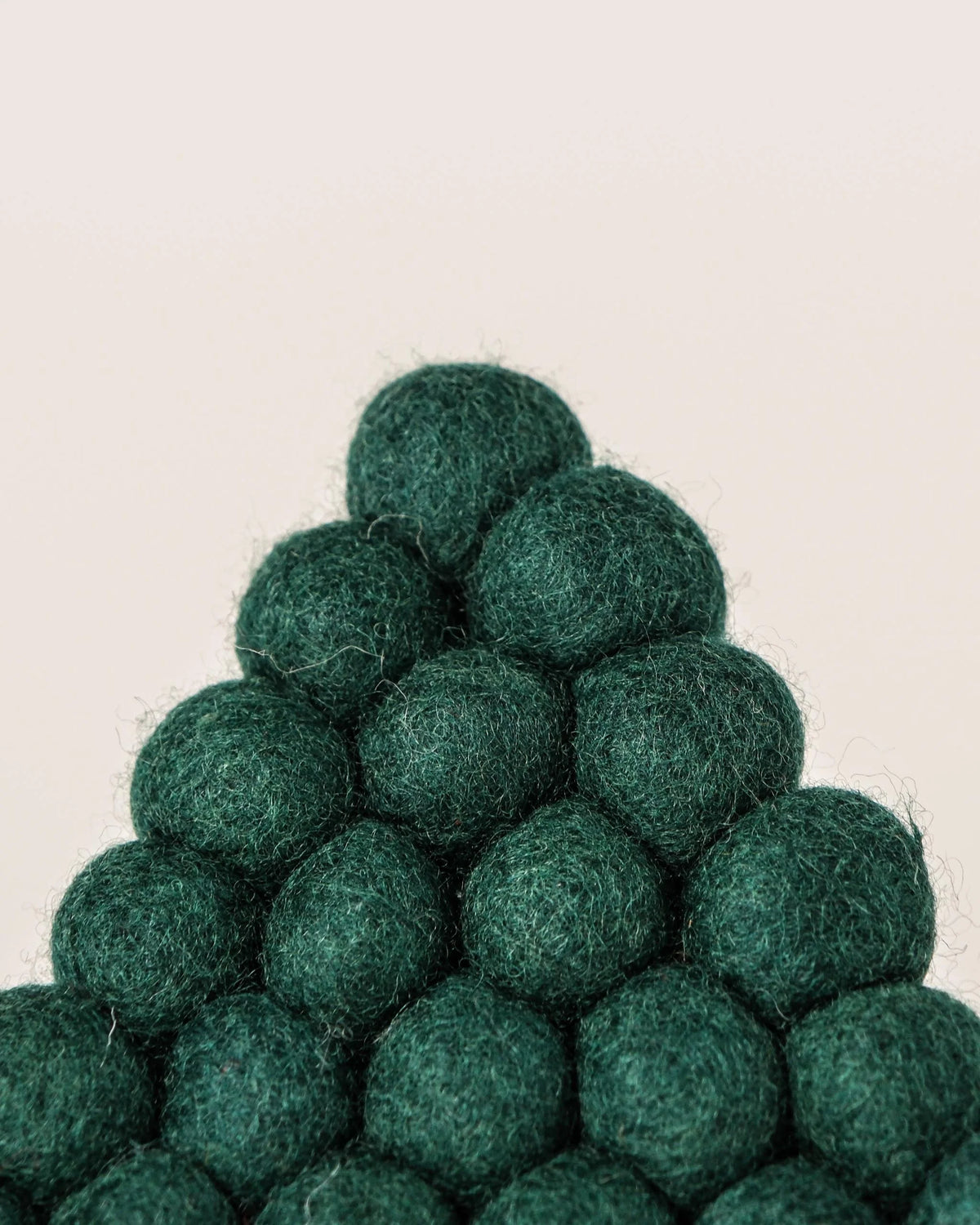 Dessous de plat boule en feutrine sapin vert sur un fond blanc zoom détail matiere.