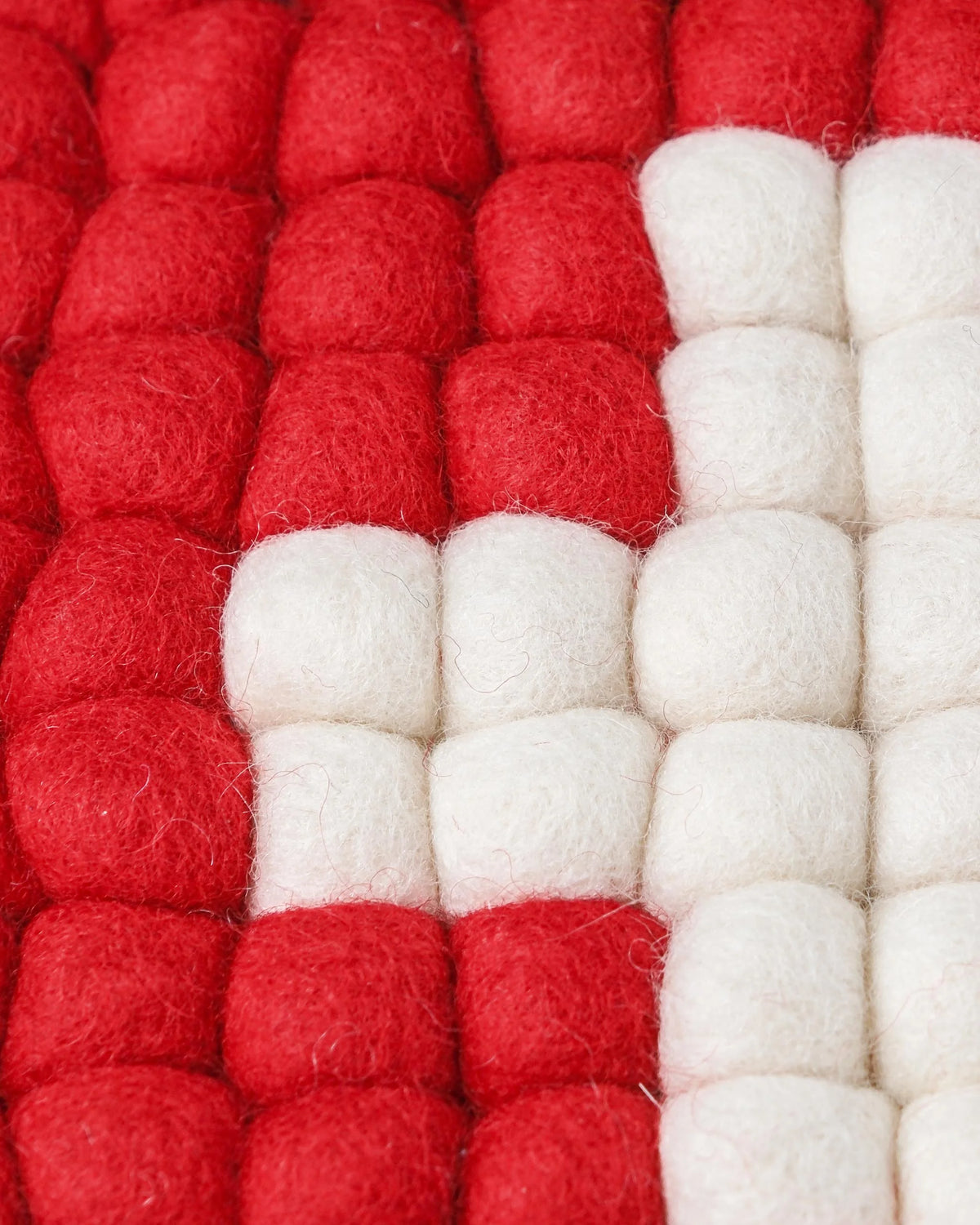 Dessous de plat boule en feutrine drapeau Suisse sur un fond blanc détail zoom matière.