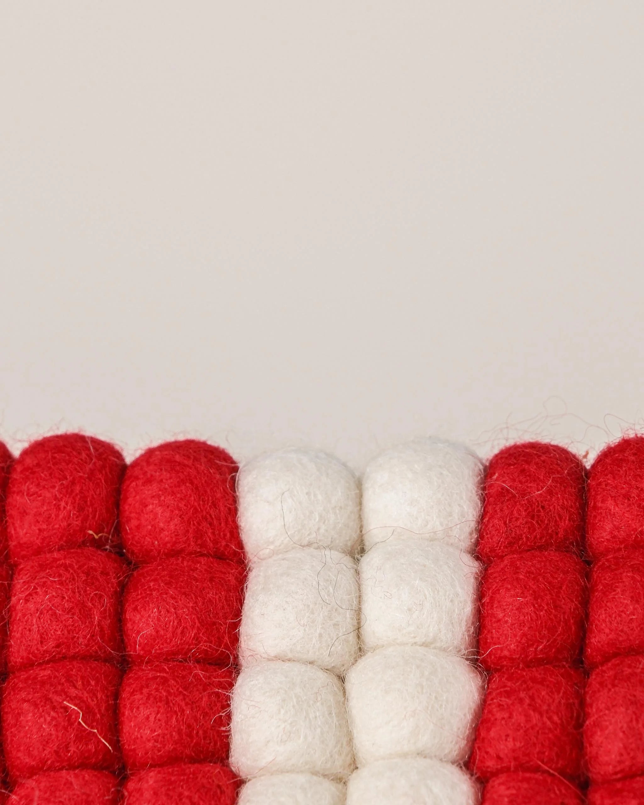 Dessous de plat boule en feutrine drapeau Savoie sur un fond blanc détail zoom matière.