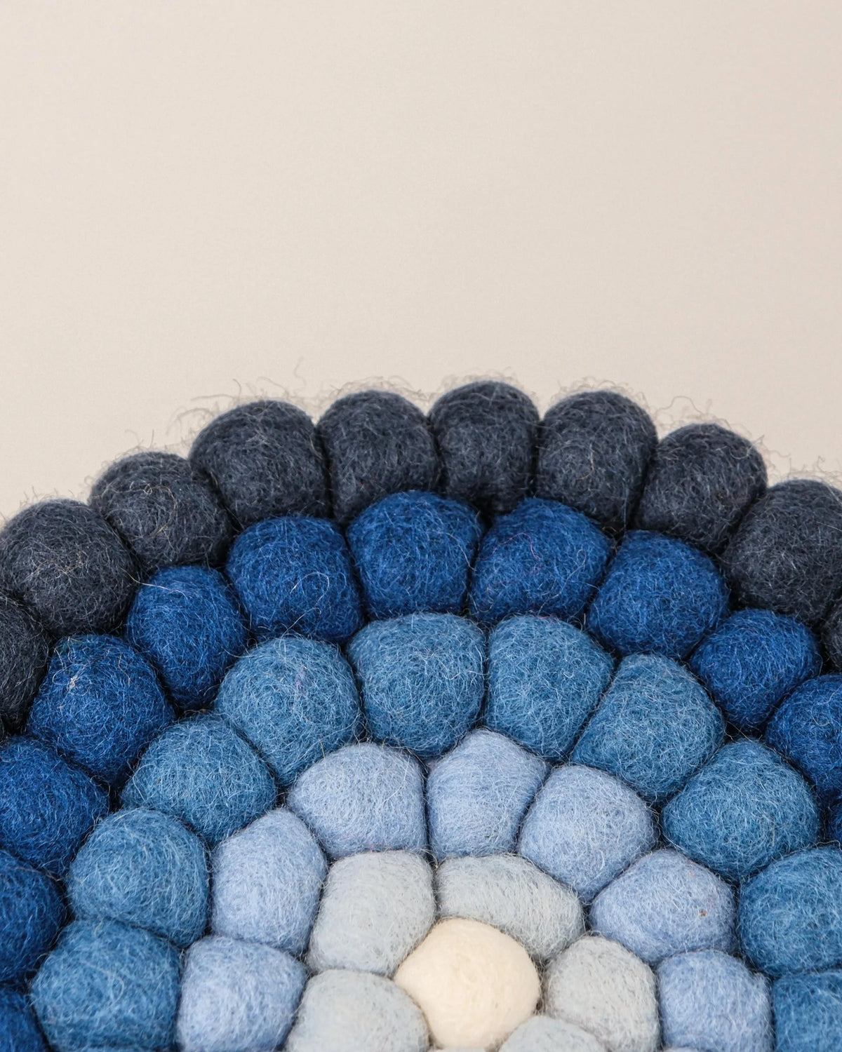 Dessous de plat boule dégradé de bleu en feutrine sur un fond blanc détail zoom matière.