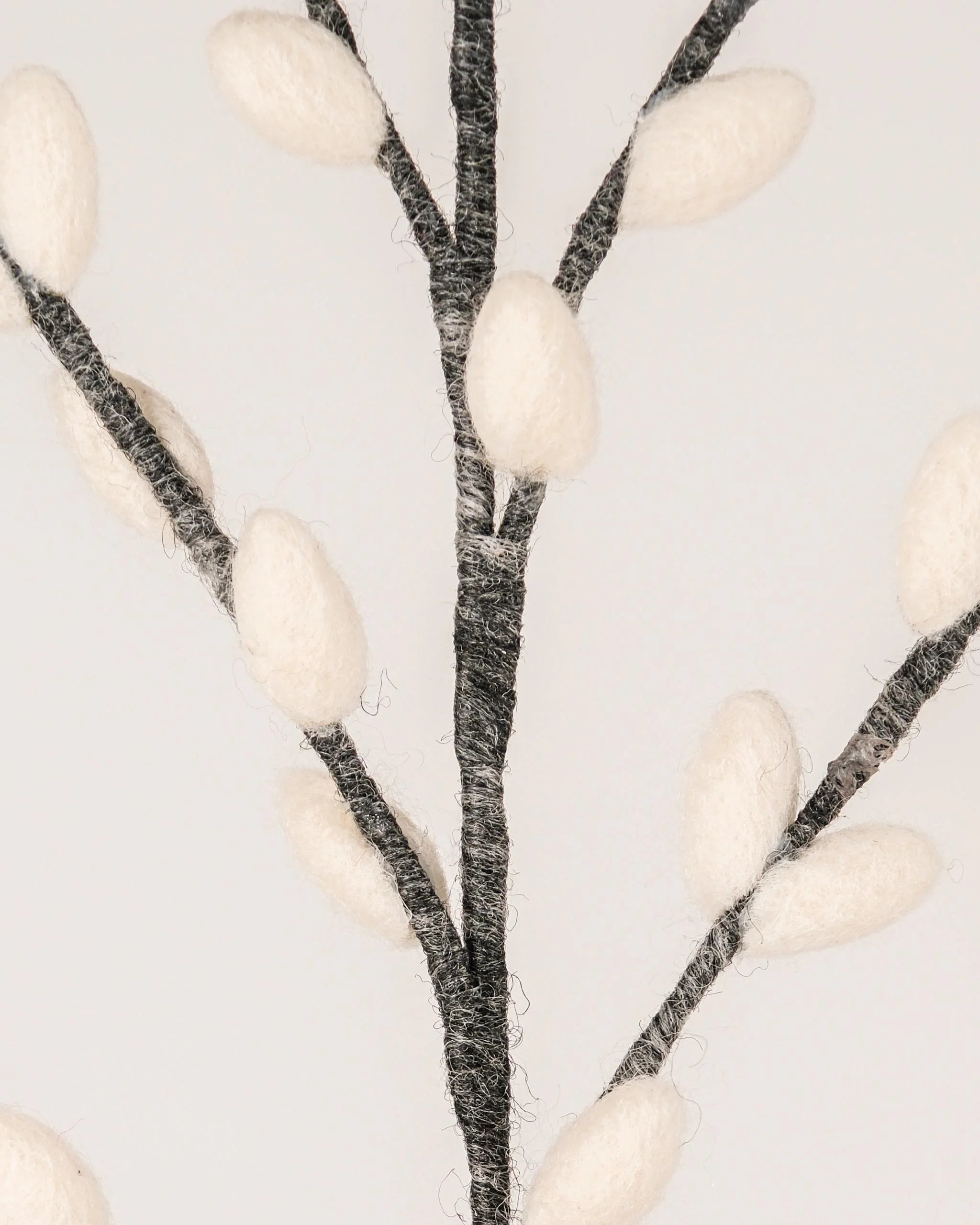 Photo zoom d'une branche de chaton de saule gris géante en feutrine sur un fond blanc style photo packshot.