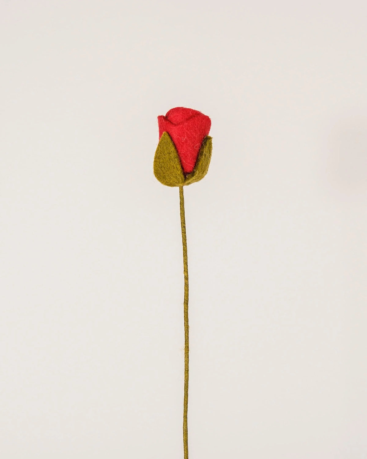 Photo d'une rose rouge en feutrine sur un fond blanc.