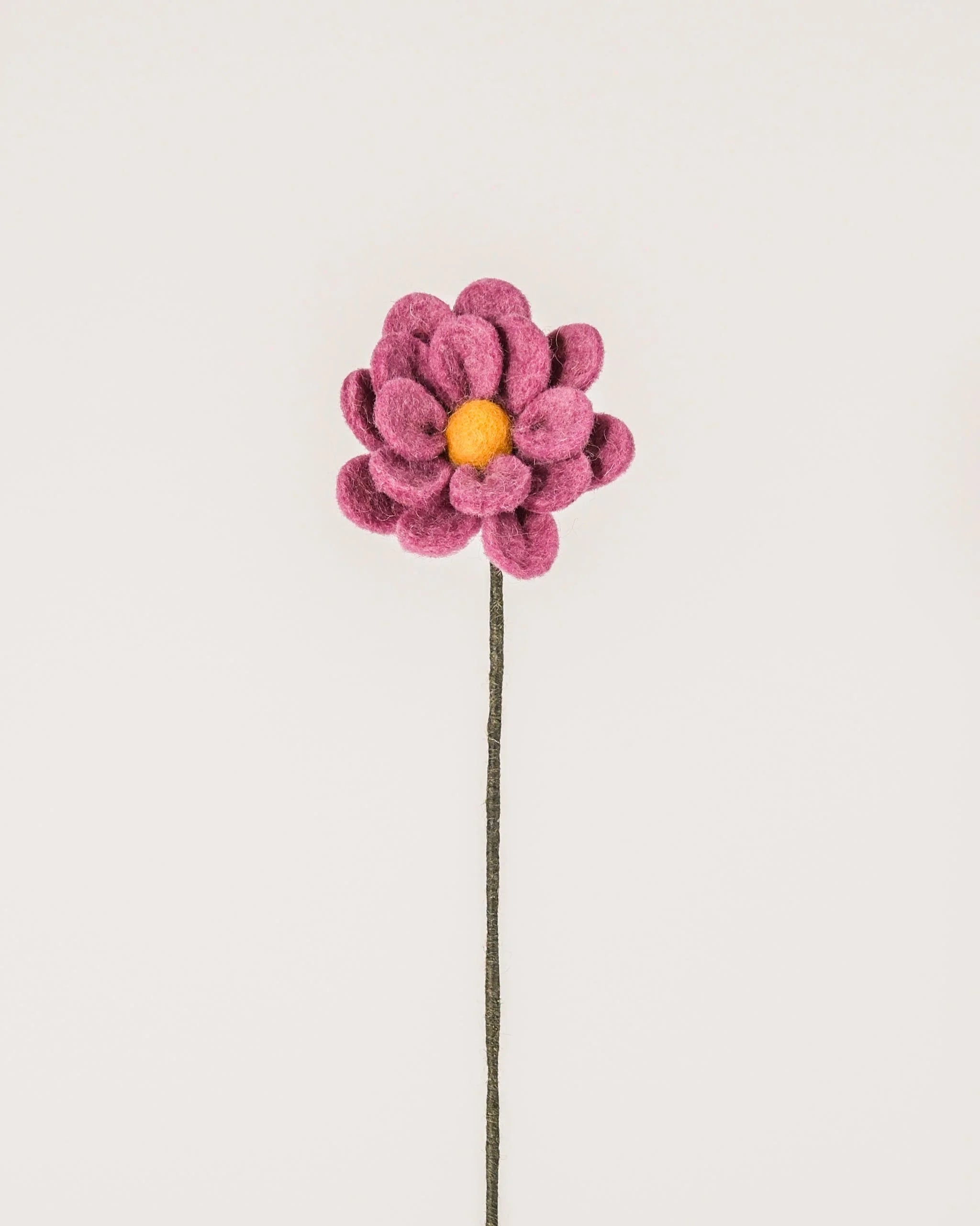 Photo d'une anémone violet clair en feutrine sur un fond blanc.