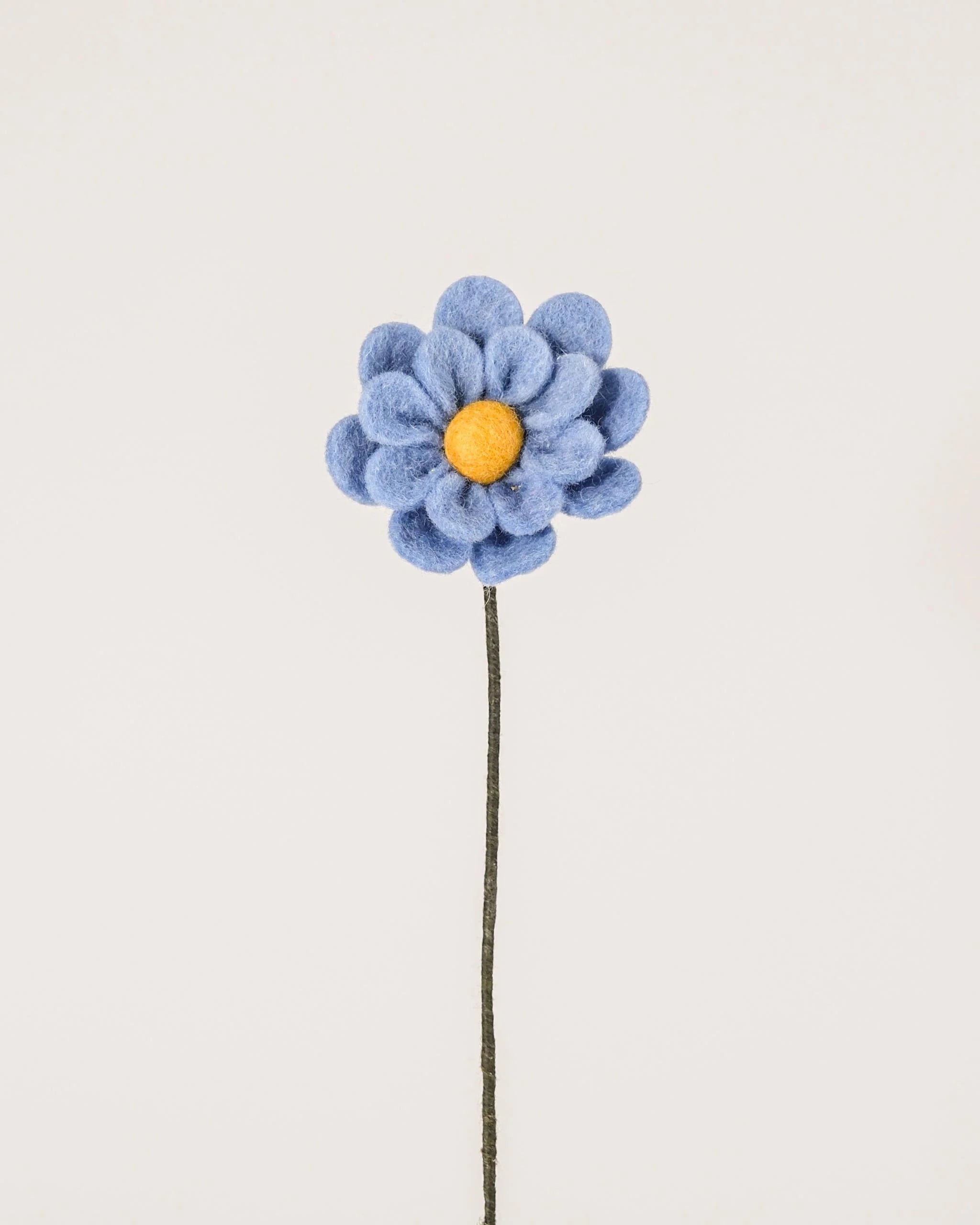 Photo d'une anémone bleu en feutrine sur un fond blanc.