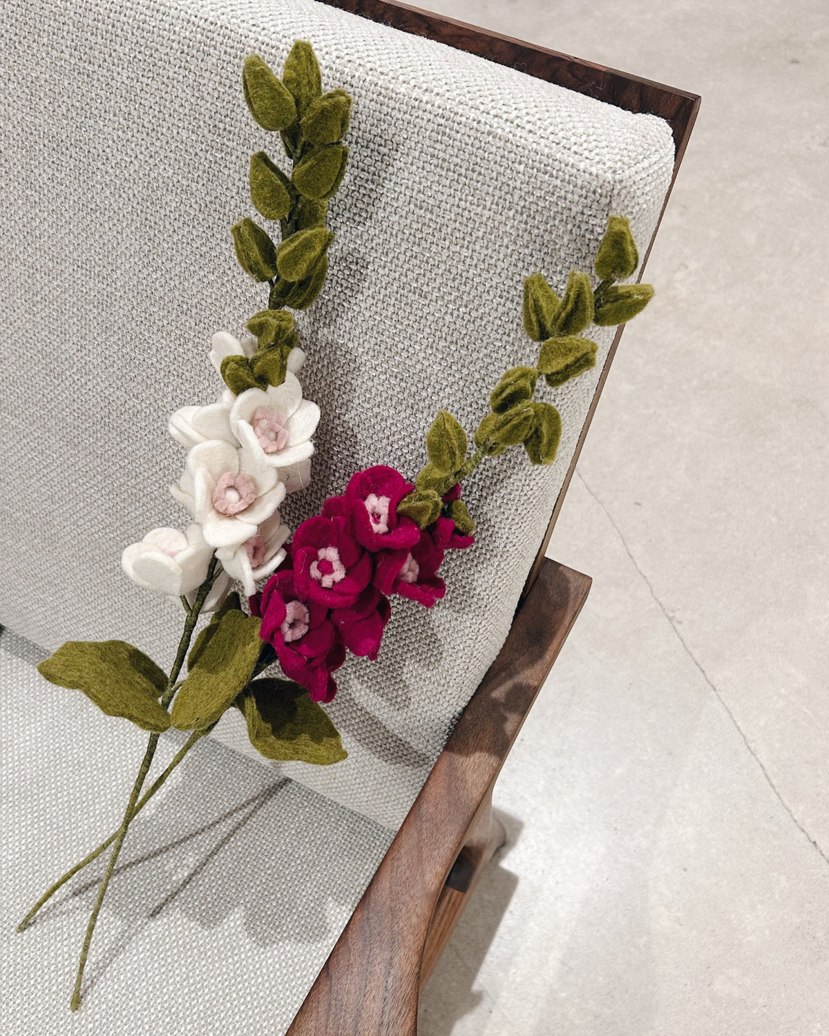 Rose trémière rose et blanche posé sur un fauteuil.