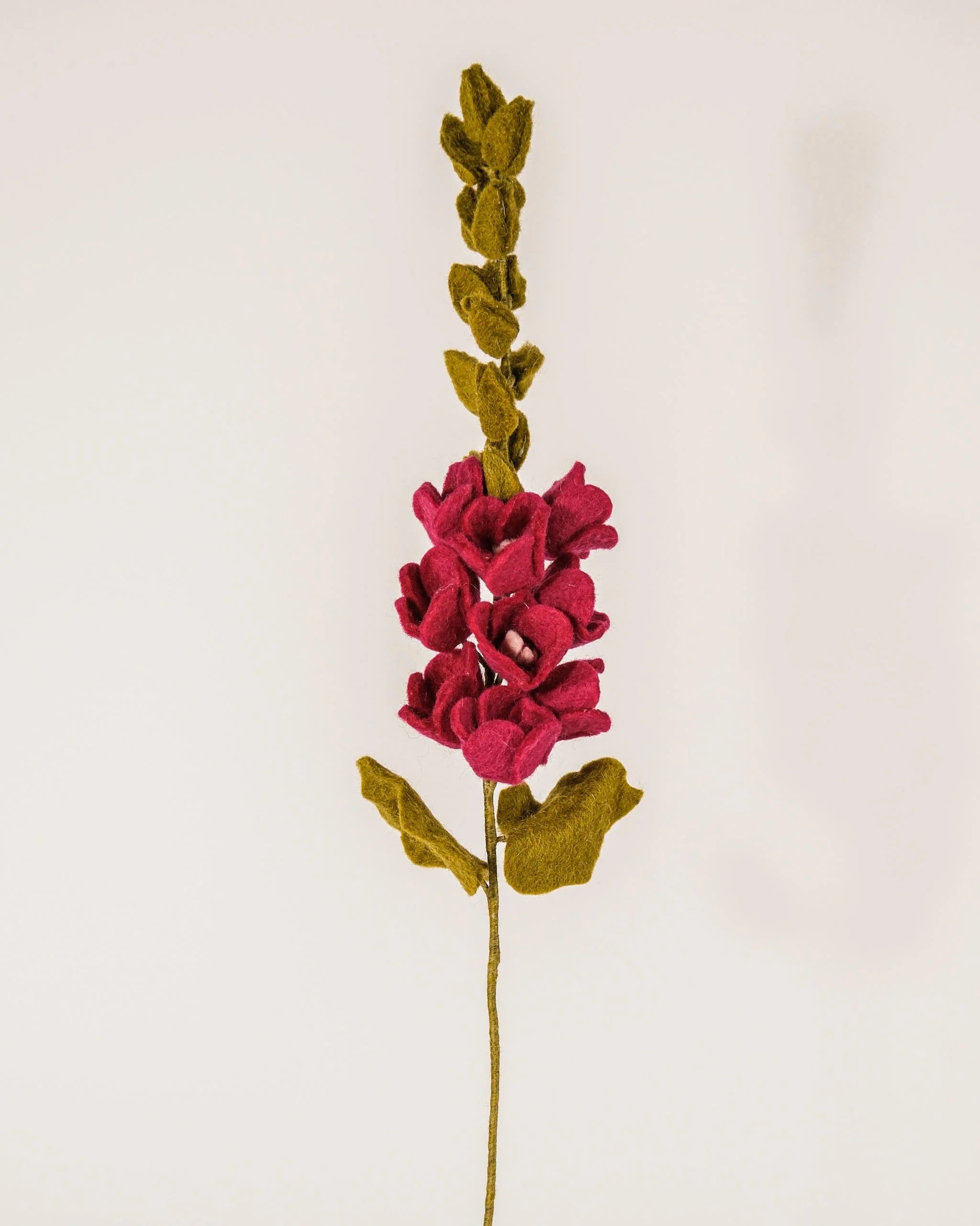 Photo d'une rose trémière rose en feutrine sur un fond blanc style photo packshot.