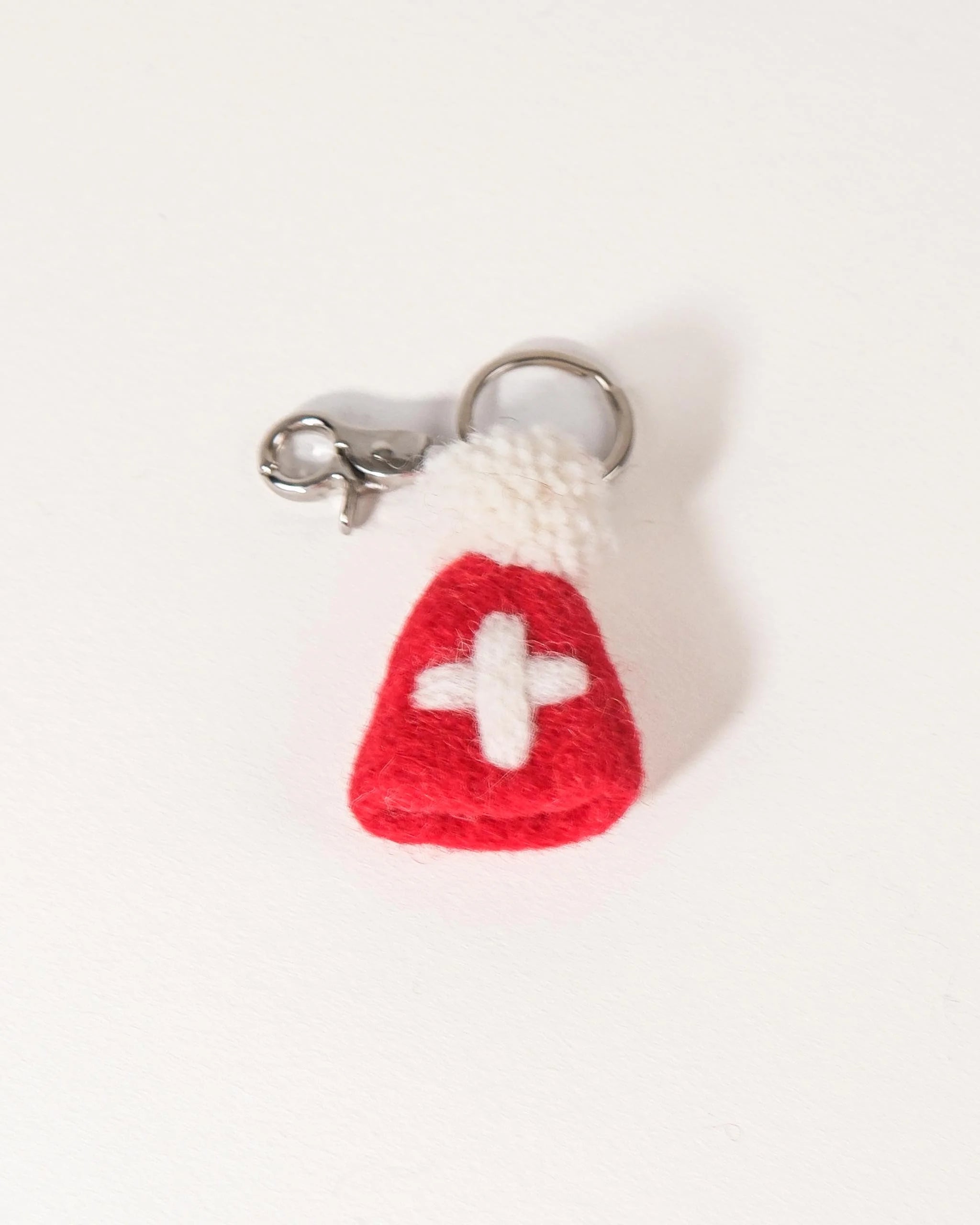 Porte clé bonnet Suisse en feutrine sur un fond blanc.