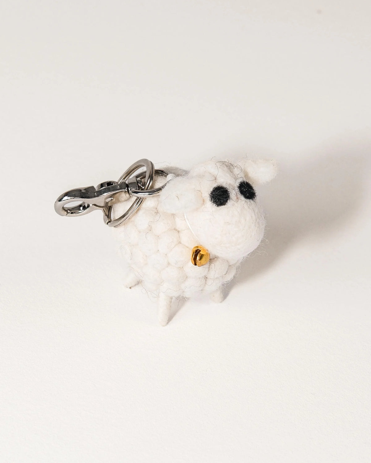Porte clé mouton blanc en feutrine sur un fond blanc.