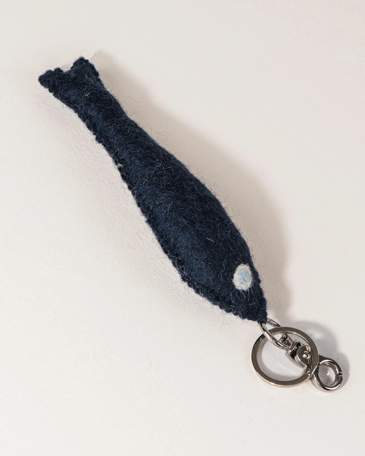Porte clé petit poisson bleu en feutrine sur un fond blanc.