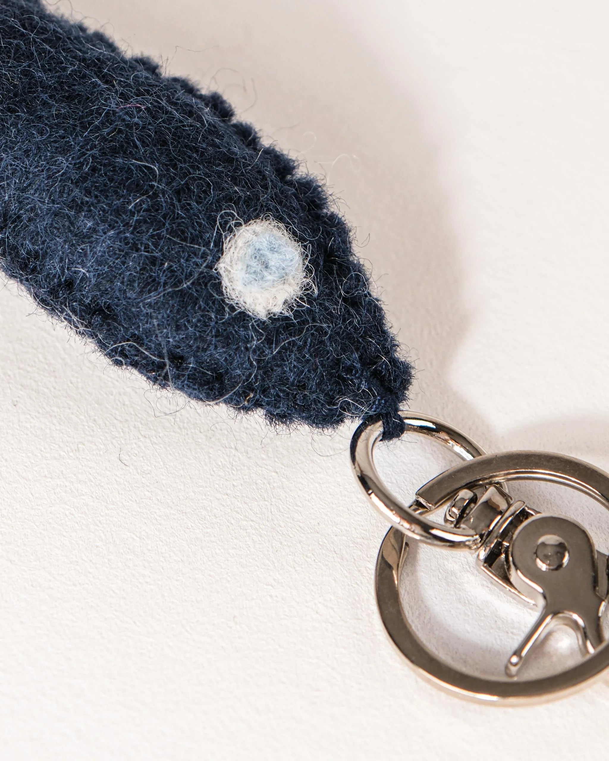 Porte clé petit poisson bleu en feutrine sur un fond blanc détail zoom matière.