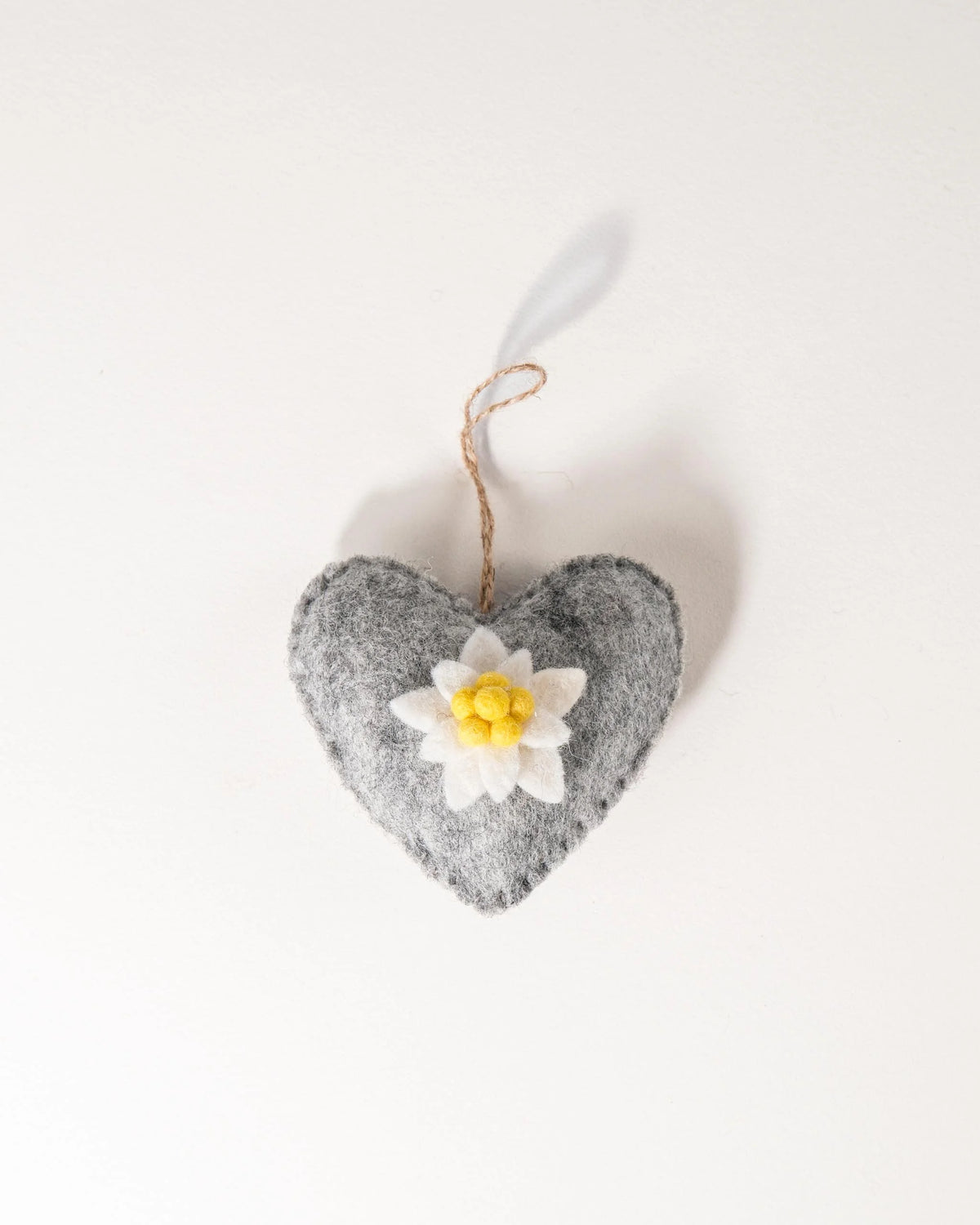 Coeur gris a suspendre avec edelweiss sur fond blanc.