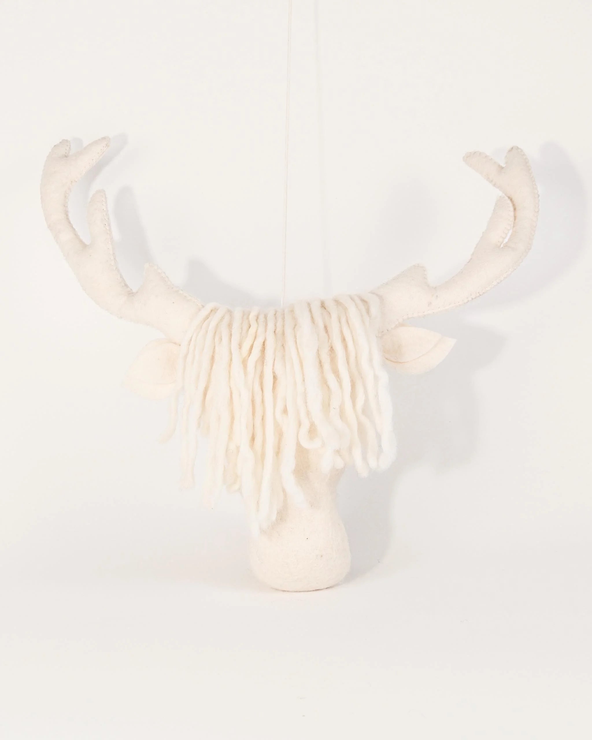 Trophée mural tête de cerf blanc en feutrine sur un fond blanc.
