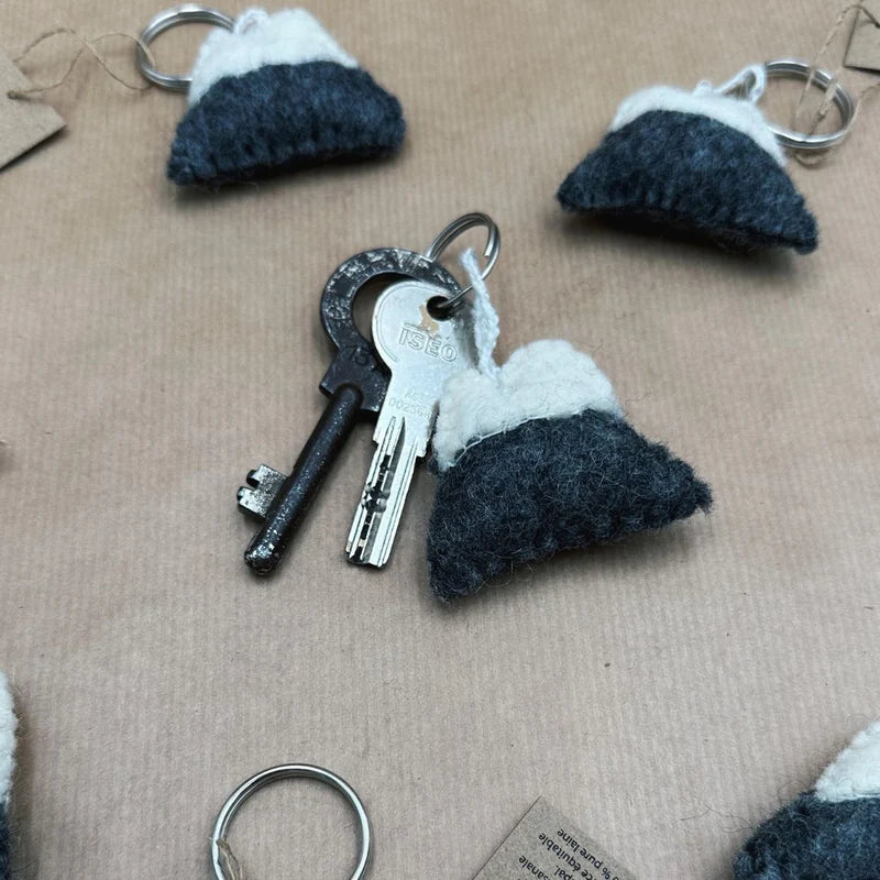 Porte-clé montagne en laine feutrée New Heidi utilisé avec un trousseau de clés.