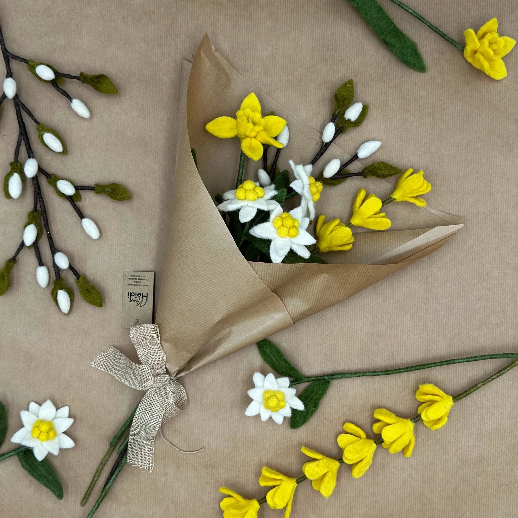 Présentation du bouquet Éclat d'Alpage New Heidi emballé dans du papier kraft avec son étiquette artisanale.