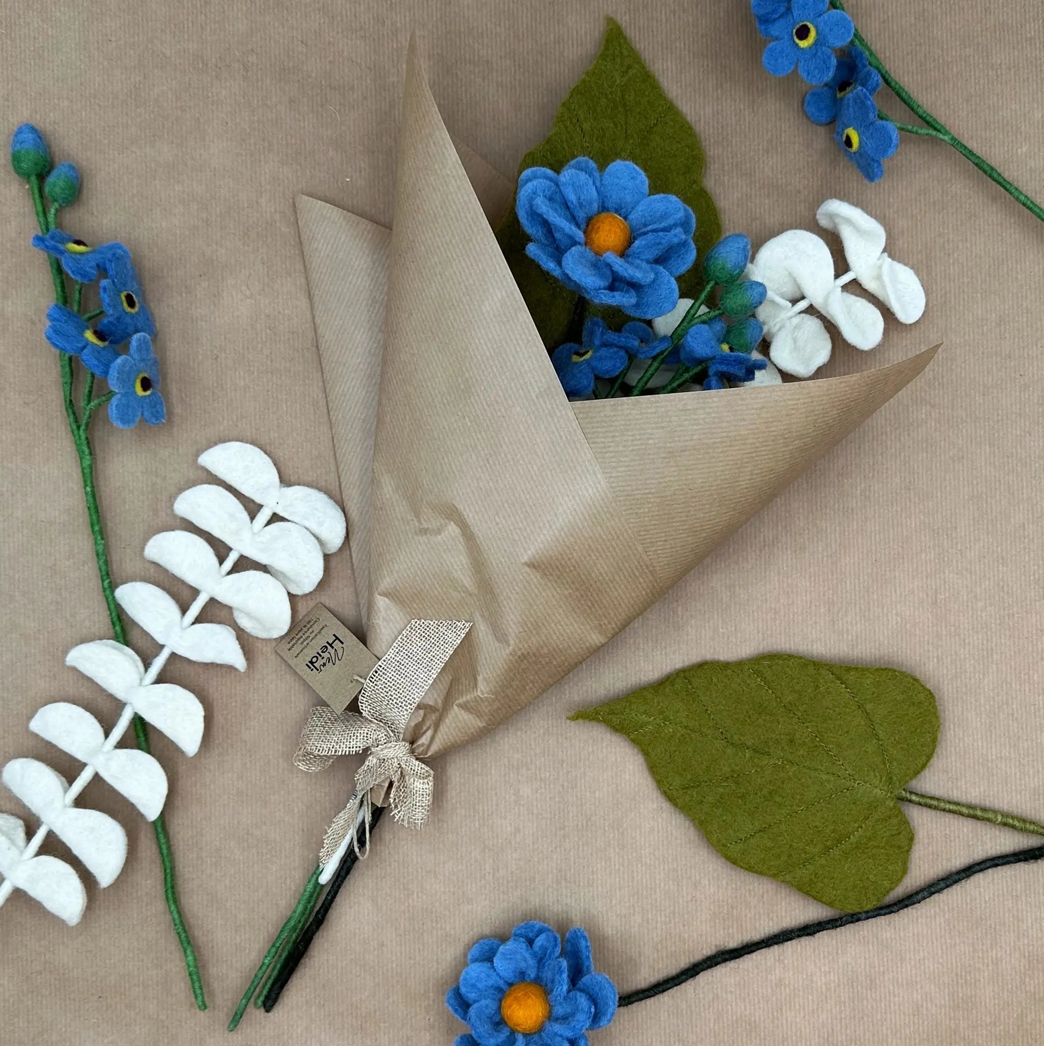 Bouquet Azur Éternel New Heidi emballé dans du papier kraft recyclé prêt à offrir.