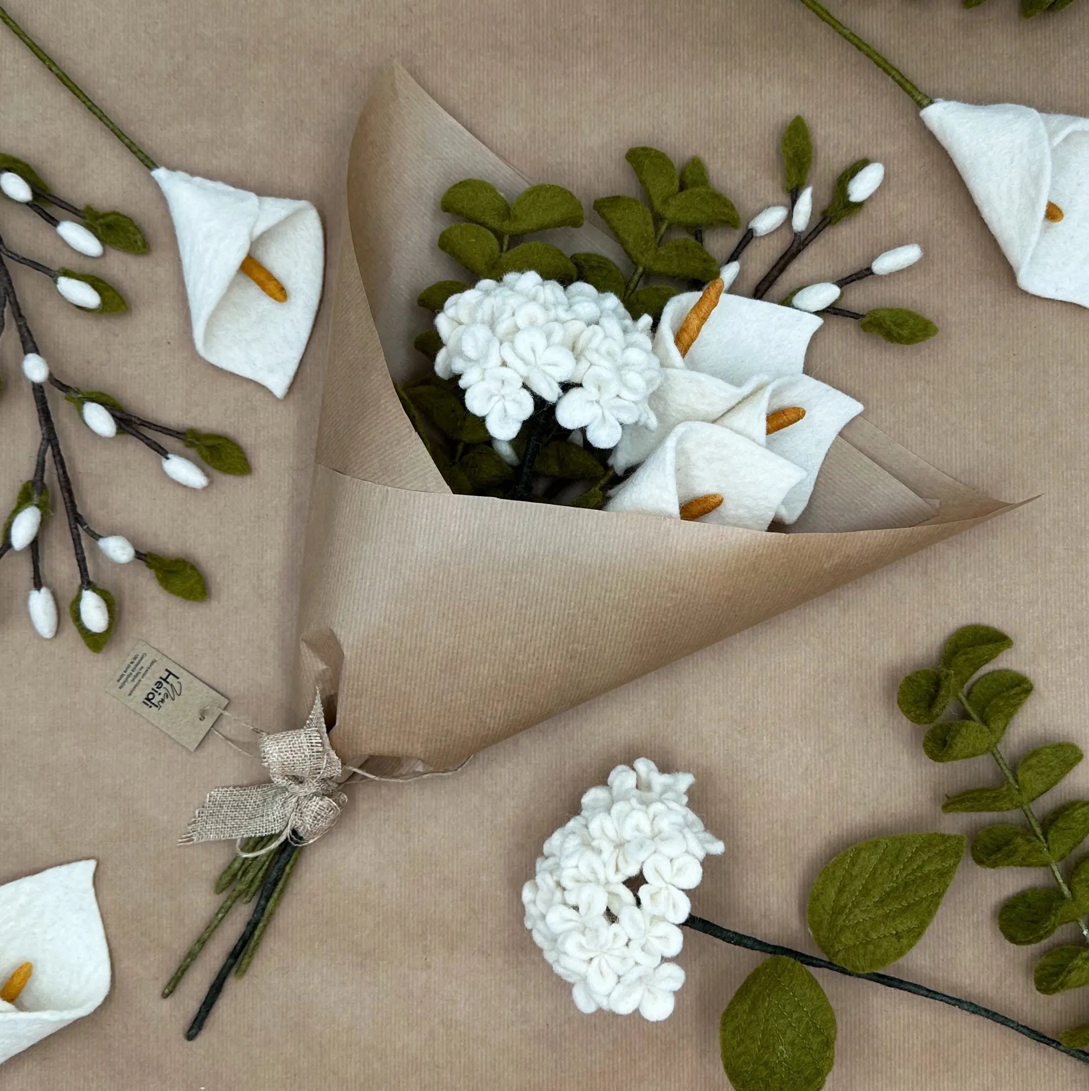 Bouquet Pureté de l'Arum New Heidi emballé dans du papier kraft recyclé prêt à offrir.