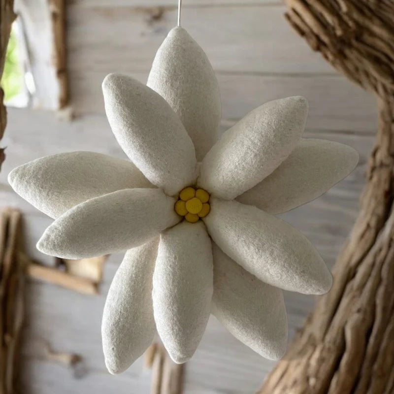 Détail des pétales et du cœur jaune texturé du coussin Edelweiss artisanal New Heidi.