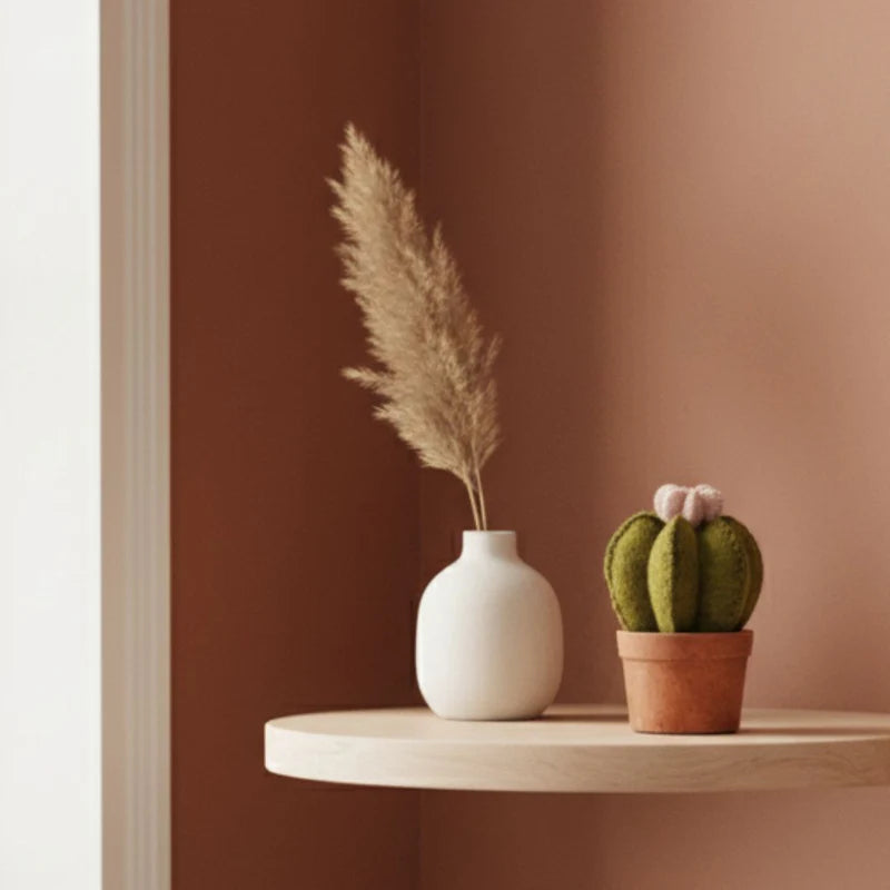 Cactus fleur New Heidi en pot disposé sur une étagère à côté d'un vase minimaliste pour une déco zen.