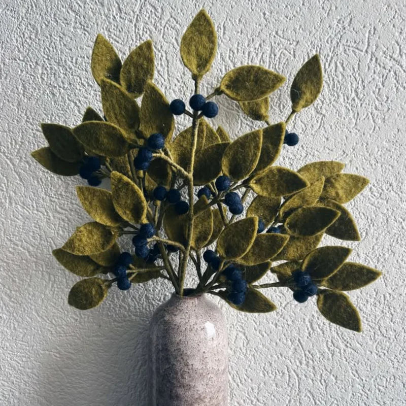Bouquet de branches de myrtilles artisanales New Heidi en laine feutrée dans un vase en grès blanc.