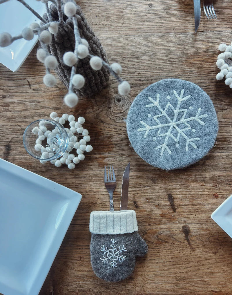 Ambiance de table hivernale avec dessous de plat flocon New Heidi, couverts et accessoires en feutrine assortis.