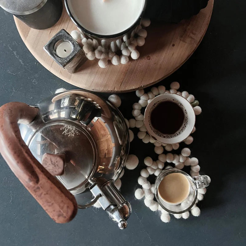 Décoration de table hivernale avec le dessous de plat flocon en laine et éléments de forêt.