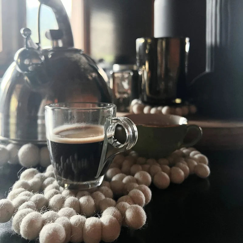 Décoration de table hivernale avec le dessous de plat flocon en laine sous une tasse à café.