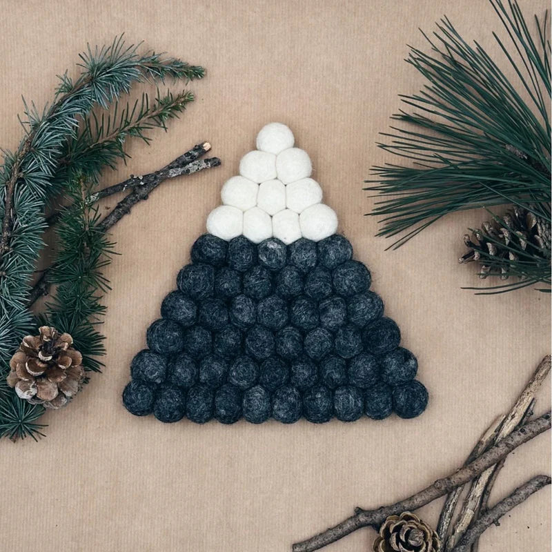 Dessous de plat New Heidi en forme de montagne enneigée composé de boules de feutrine grises et blanches.