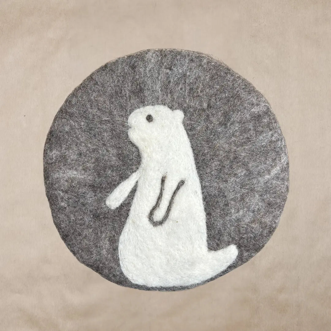 Dessous de plat rond en feutrine grise avec motif de marmotte blanche brodé artisanalement par New Heidi.