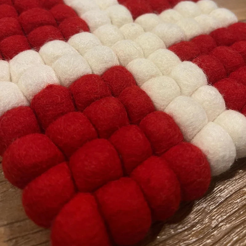 Détail de la croix de Savoie artisanale en boules de laine feutrée New Heidi.