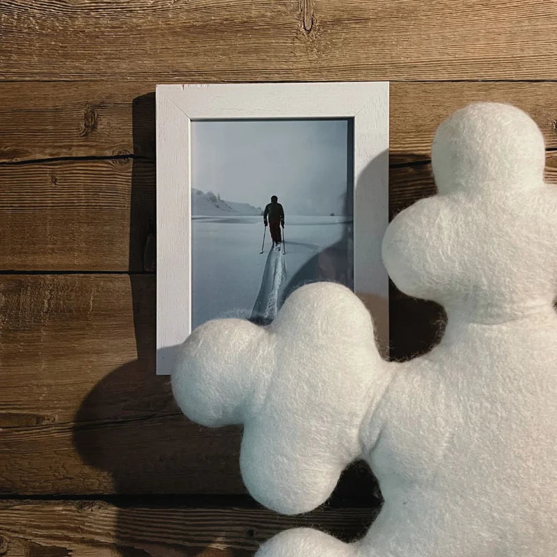 Détail de la forme sculpturale du coussin flocon de neige New Heidi en laine feutrée blanche.