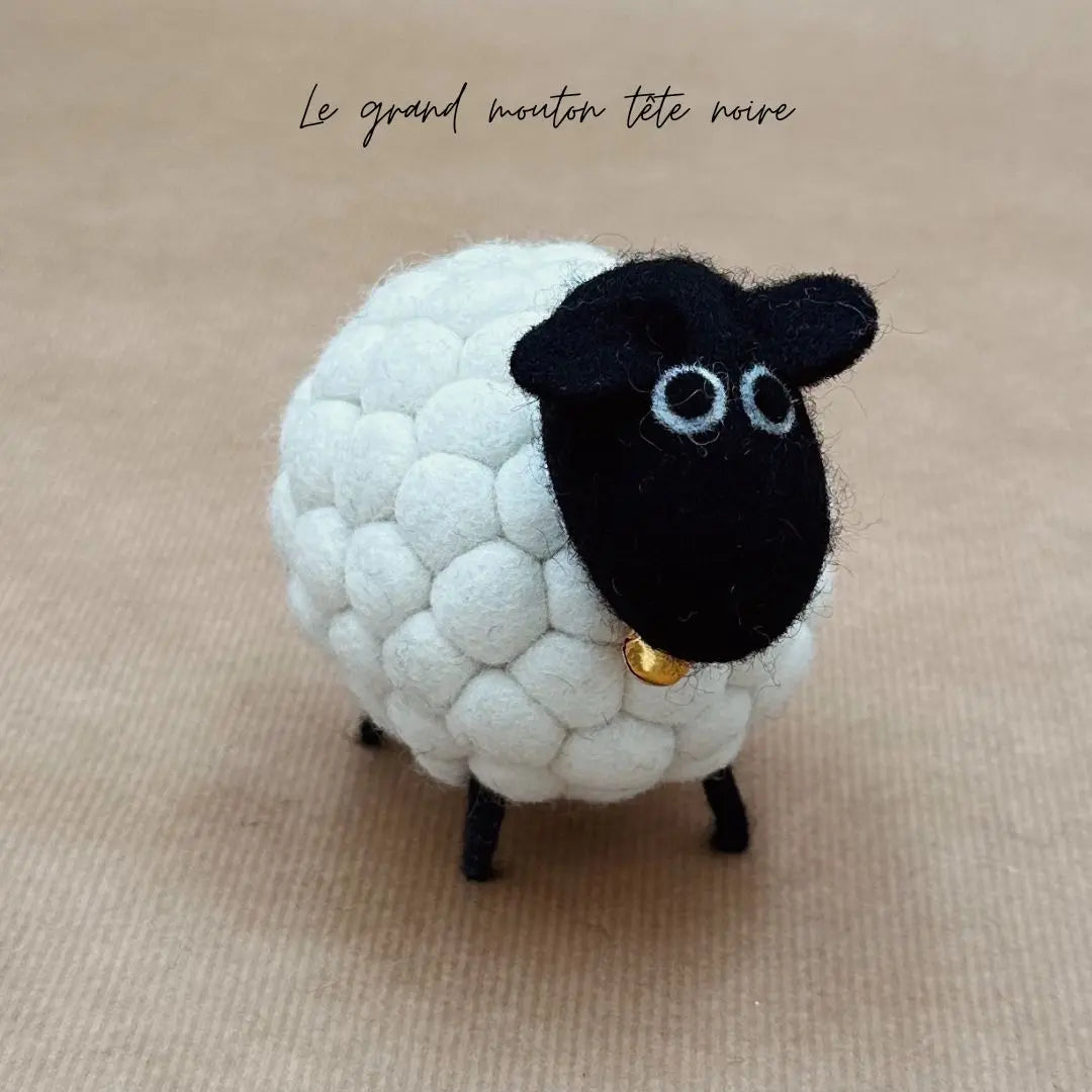Grand mouton tête noire New Heidi en feutrine blanche bouclée artisanale vue de profil avec petite cloche.