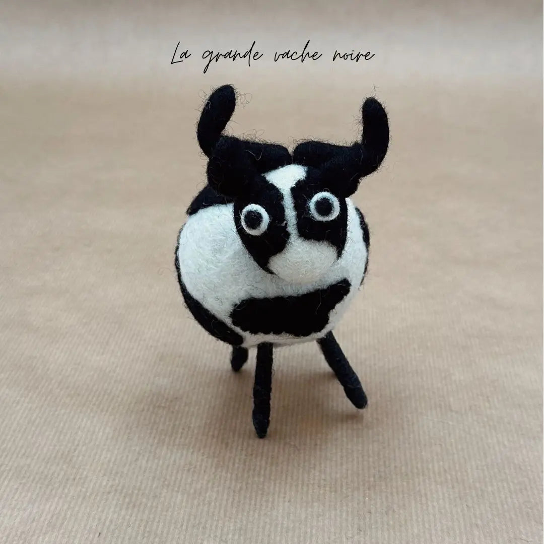 Grande vache boule noire et blanche New Heidi en feutrine artisanale vue de face.