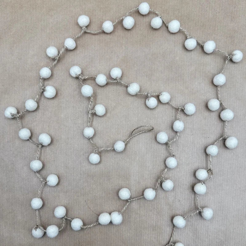 Vue à plat de la guirlande de boules en laine blanche New Heidi, fabrication artisanale du Népal.