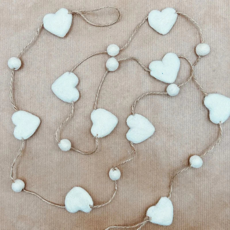 Guirlande décorative New Heidi composée de cœurs et de billes en laine feutrée blanche.