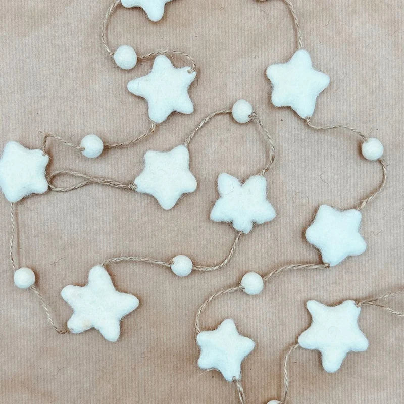 Détail de la guirlande étoile New Heidi en laine posée sur fond kraft, fabrication éthique du Népal.