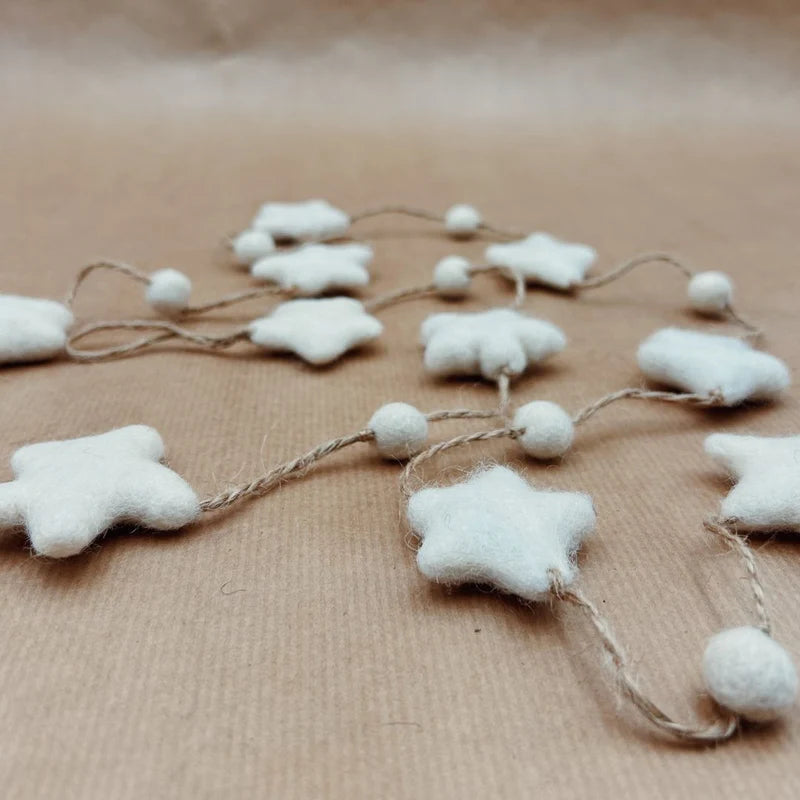 Guirlande décorative New Heidi composée d'étoiles et de billes en laine feutrée blanche.