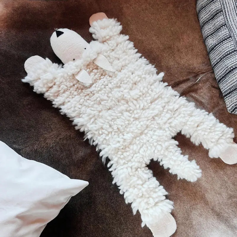 Tapis en forme de mouton New Heidi en laine feutrée bouclée blanche, dimensions 100x40cm.
