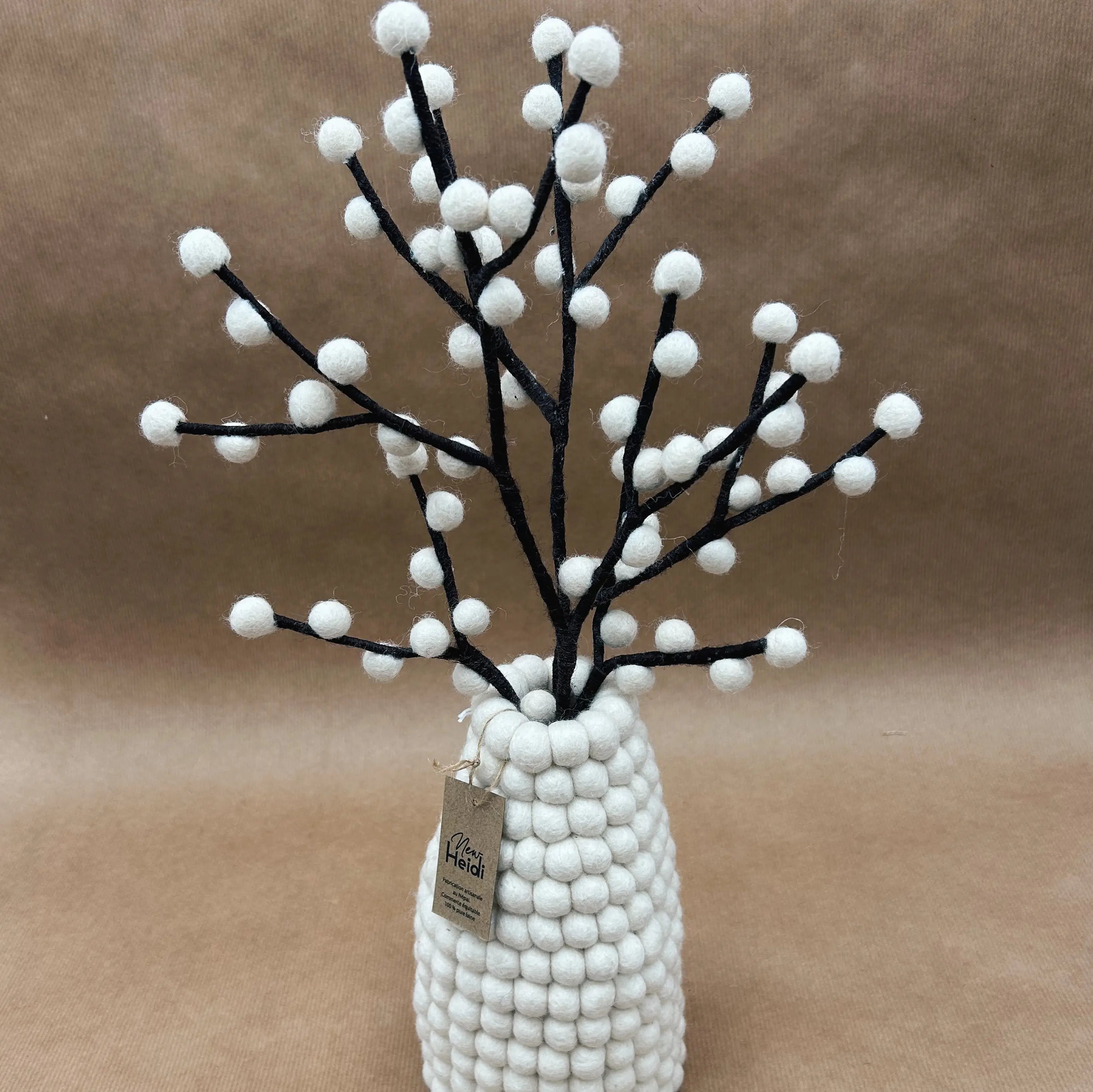 Vase blanc en feutrine New Heidi garni de branches décoratives de baies blanches artisanales.