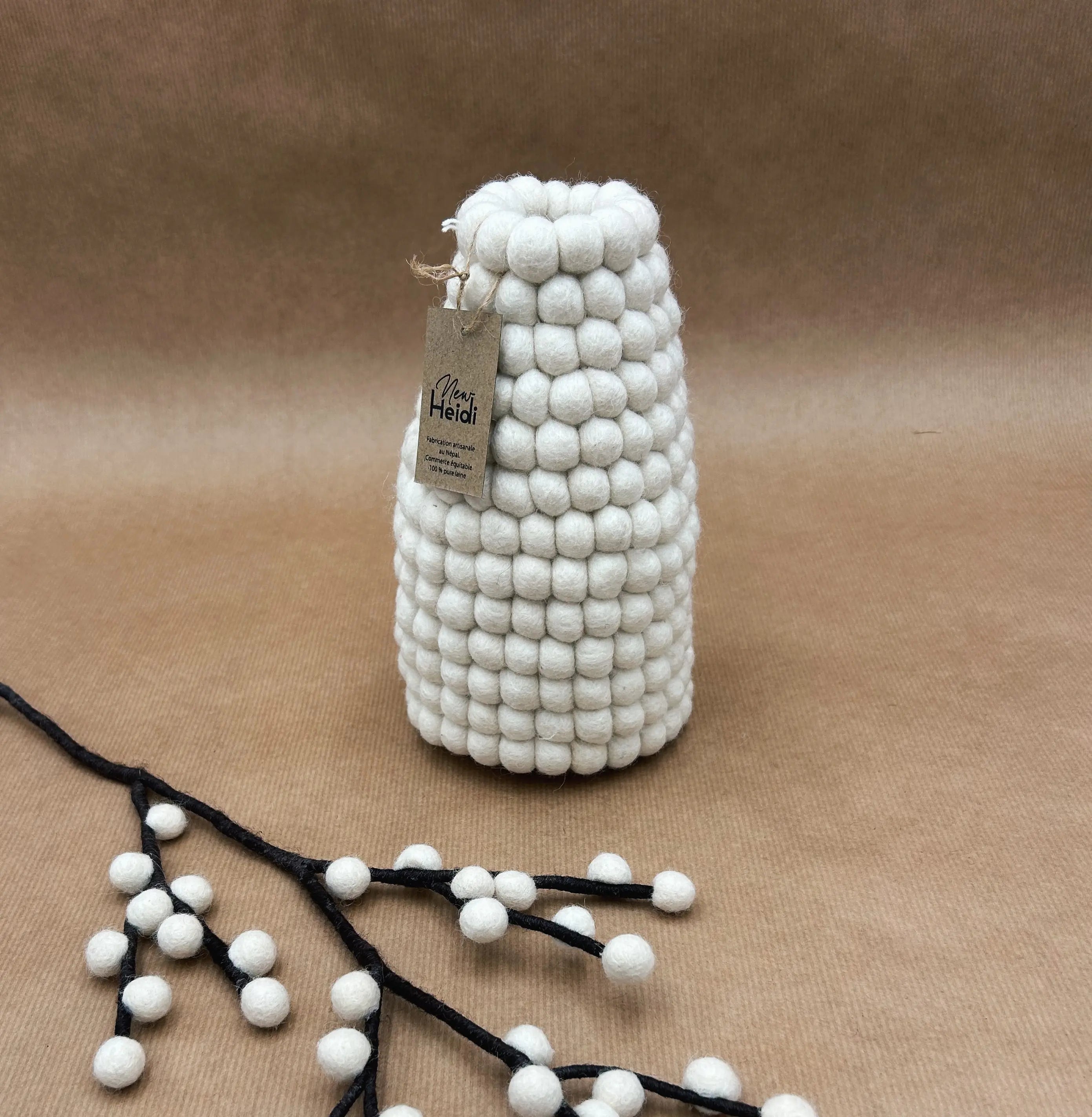 Vase artisanal en boules de feutrine blanche New Heidi avec son étiquette certifiant le fait main au Népal.