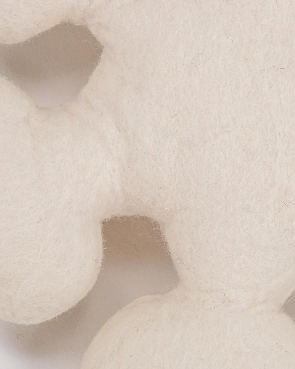 Coussin décoratif flocon en feutrine sur fond blanc détail zoom matière.