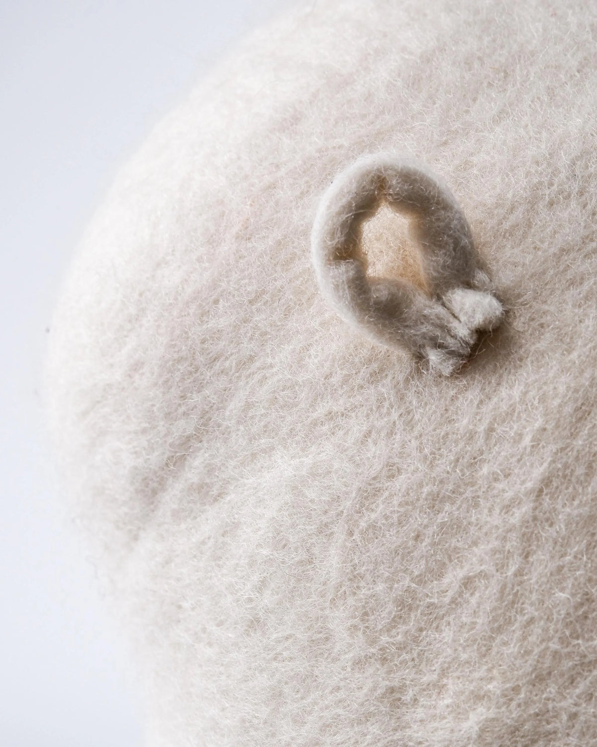 Coussin décoratif nuage en feutrine sur fond blanc accroche.