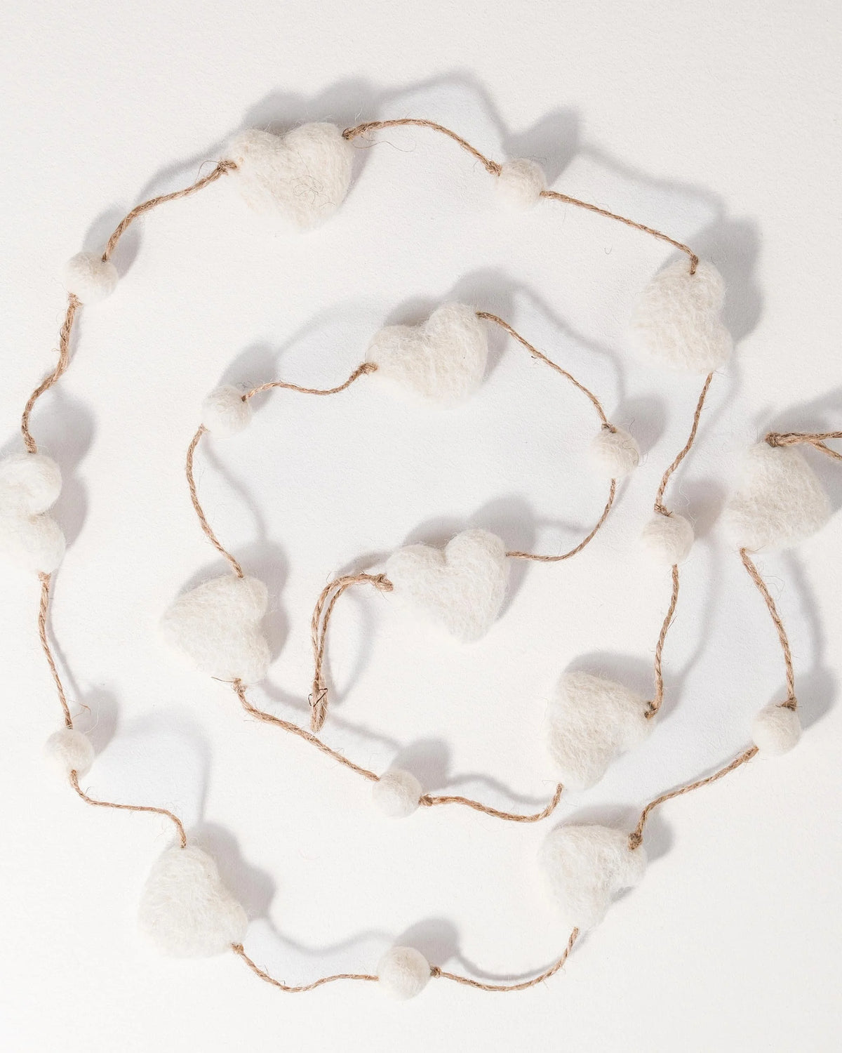 Guirlande coeur en feutrine sur un fond blanc.