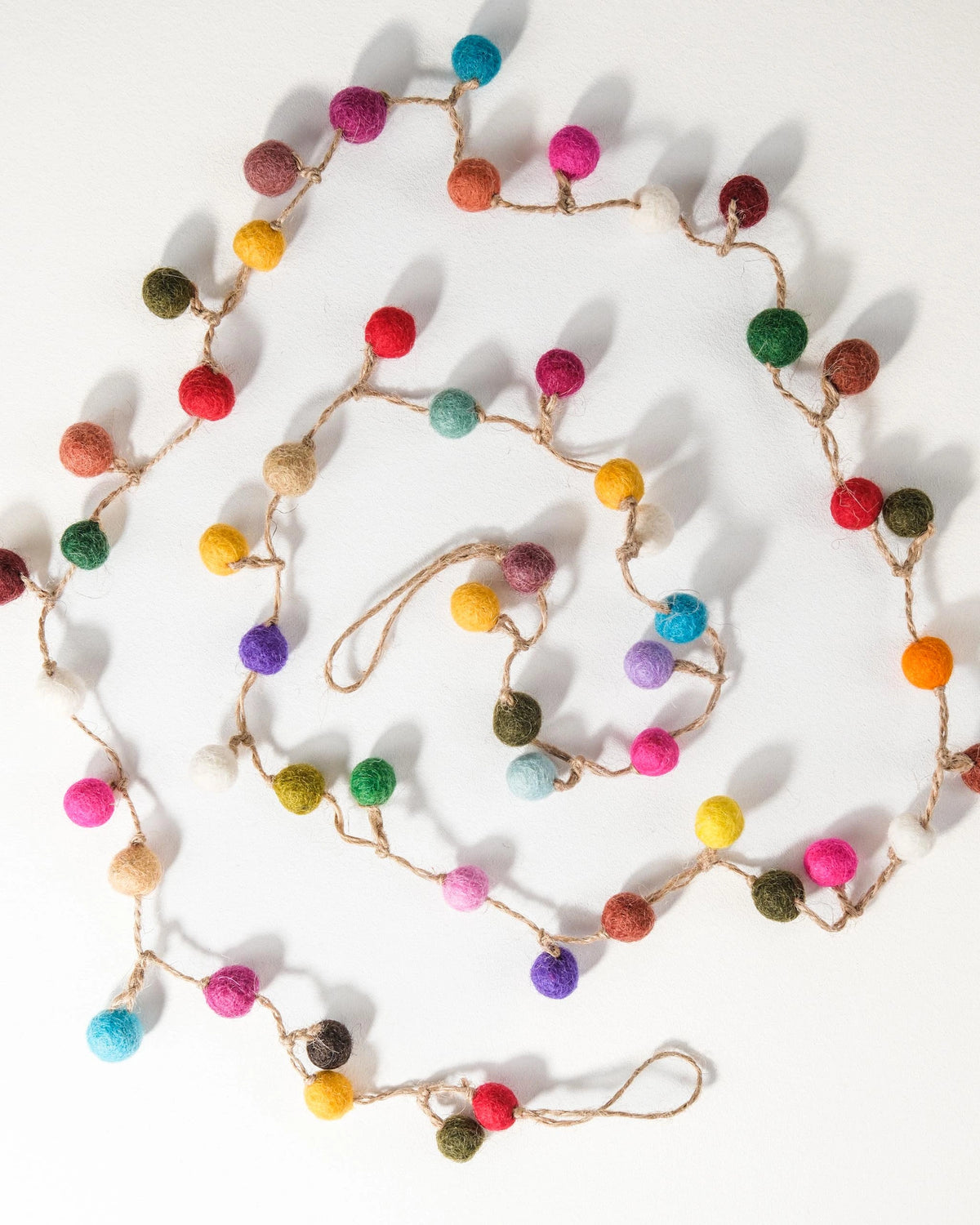 GUIRLANDE PETITE BOULE MULTICOLORE SUR UN FOND BLANC.