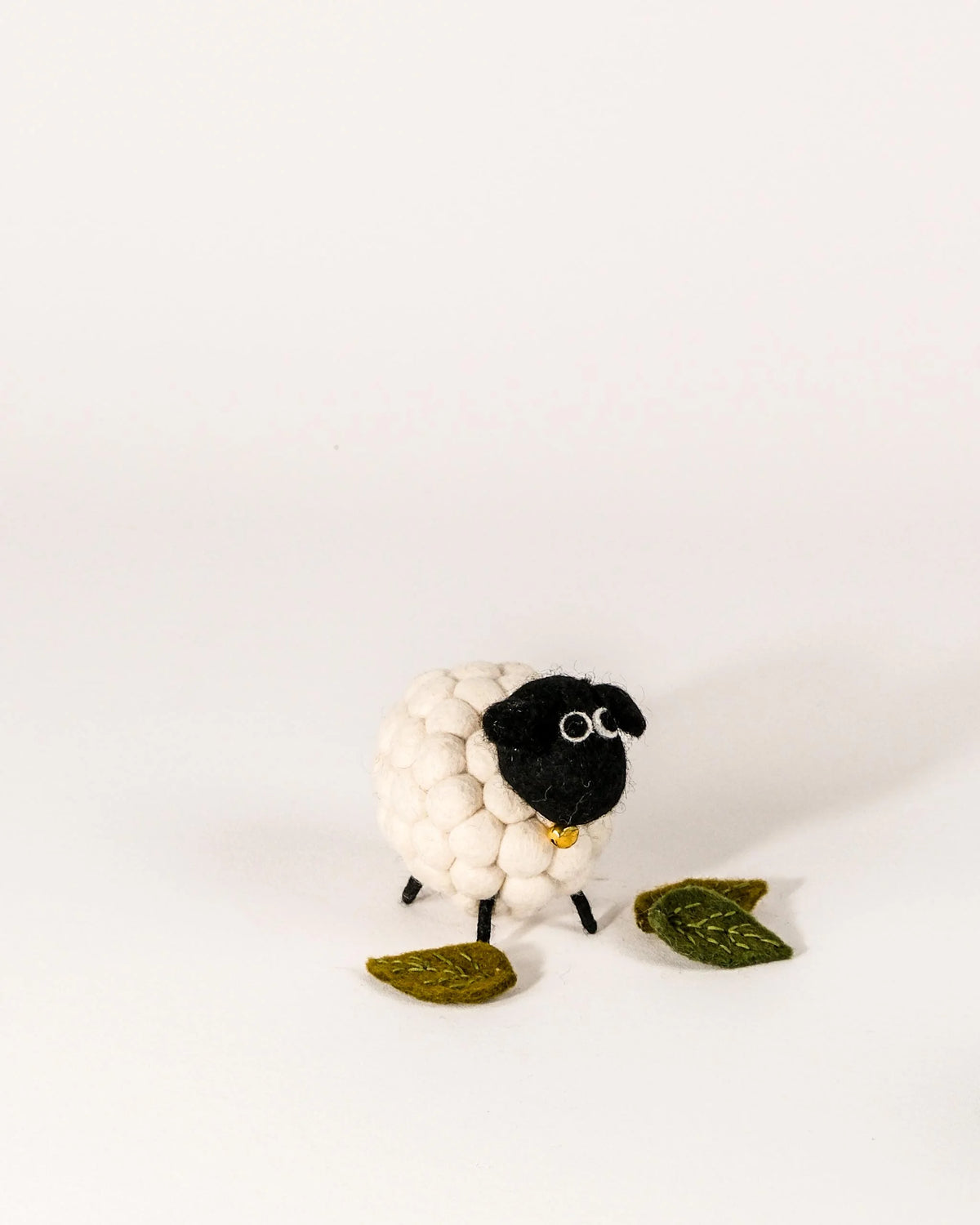 Grand mouton boule tête noir sur un fond blanc.